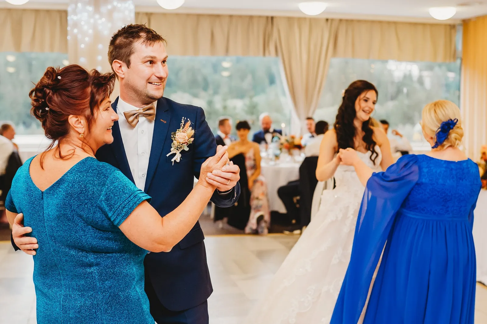 Ženích tancuje so ženou v tyrkysových šatách, vedľa nevesta s dámou v modrom – svadba Majka a Marek, Hotel Máj, Liptovský Ján