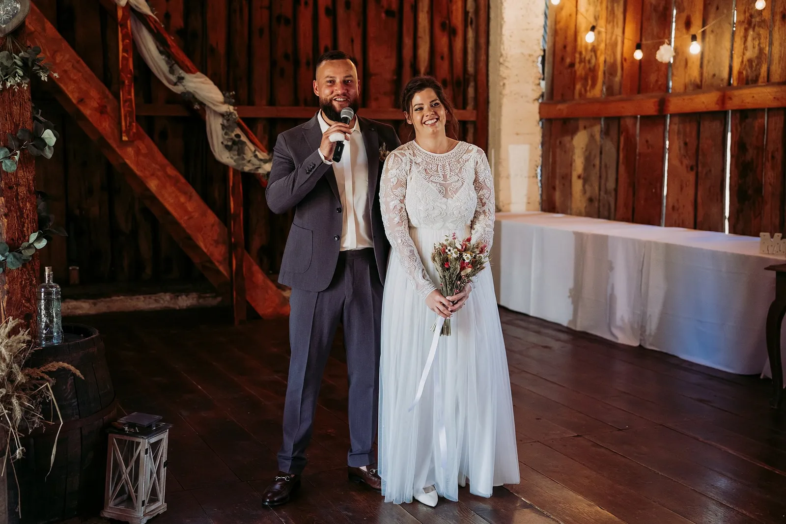 Ženích s mikrofónom a nevesta s kyticou vítajú hostí v drevenej stodole – svadba Ivka a Ondro, Humno Trnka, Záskov