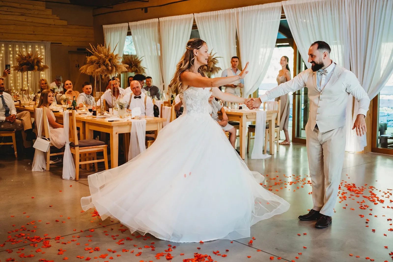 Nevesta sa točí v nadýchaných šatách pri prvom tanci s ženíchom medzi lupeňmi ruží – svadba Simonka a Nuri, Stodola Liptovský dvor