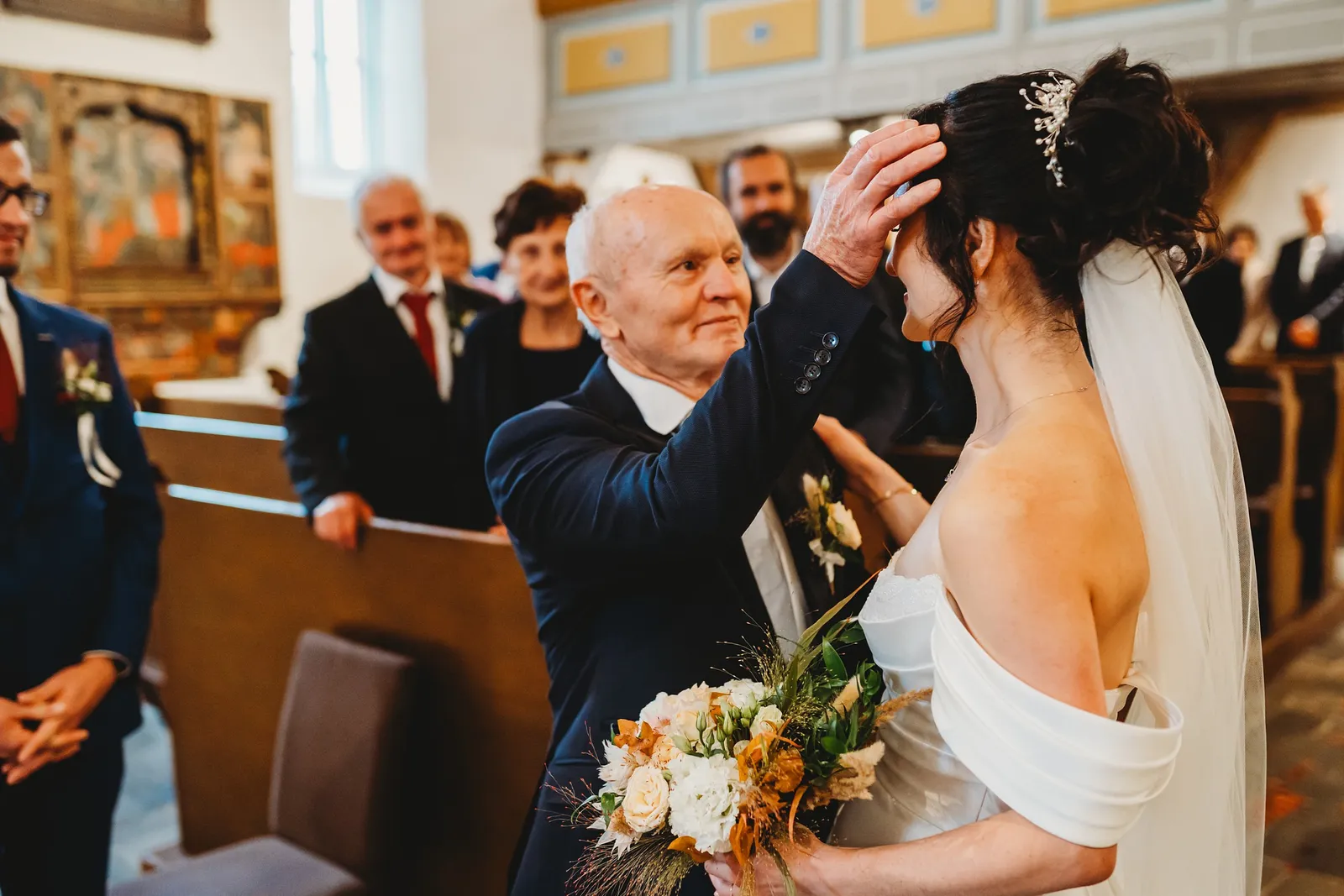 Starší muž pred oltárom žehná neveste rukou na hlave, nevesta drží kyticu – svadba Andrejka a Janko, Stodola Liptovský dvor