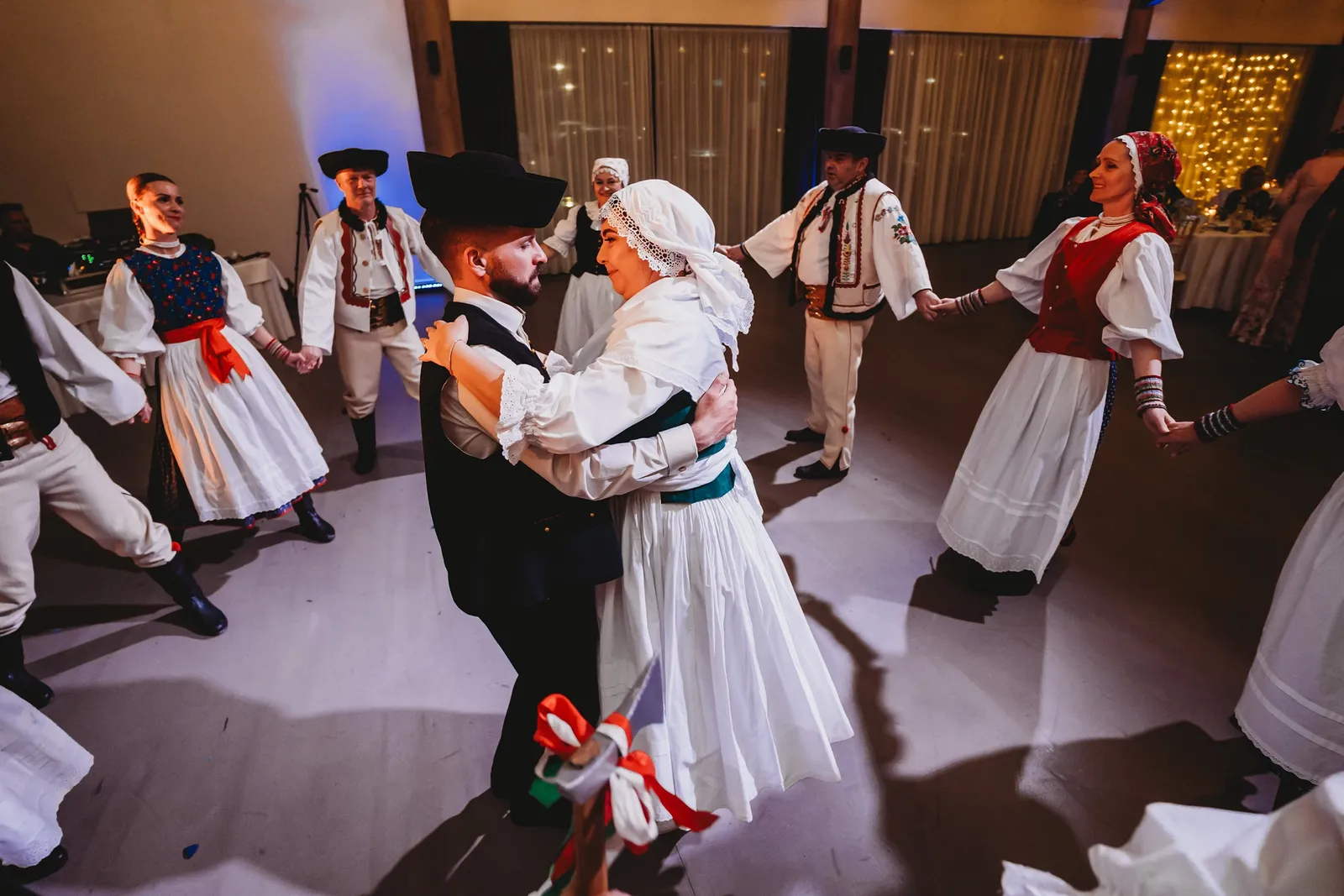 Novomanželia v krojoch tancujú v kruhu folklórneho súboru po čepčení na parkete – svadba Natália a Tomáš, Hotel Demänová